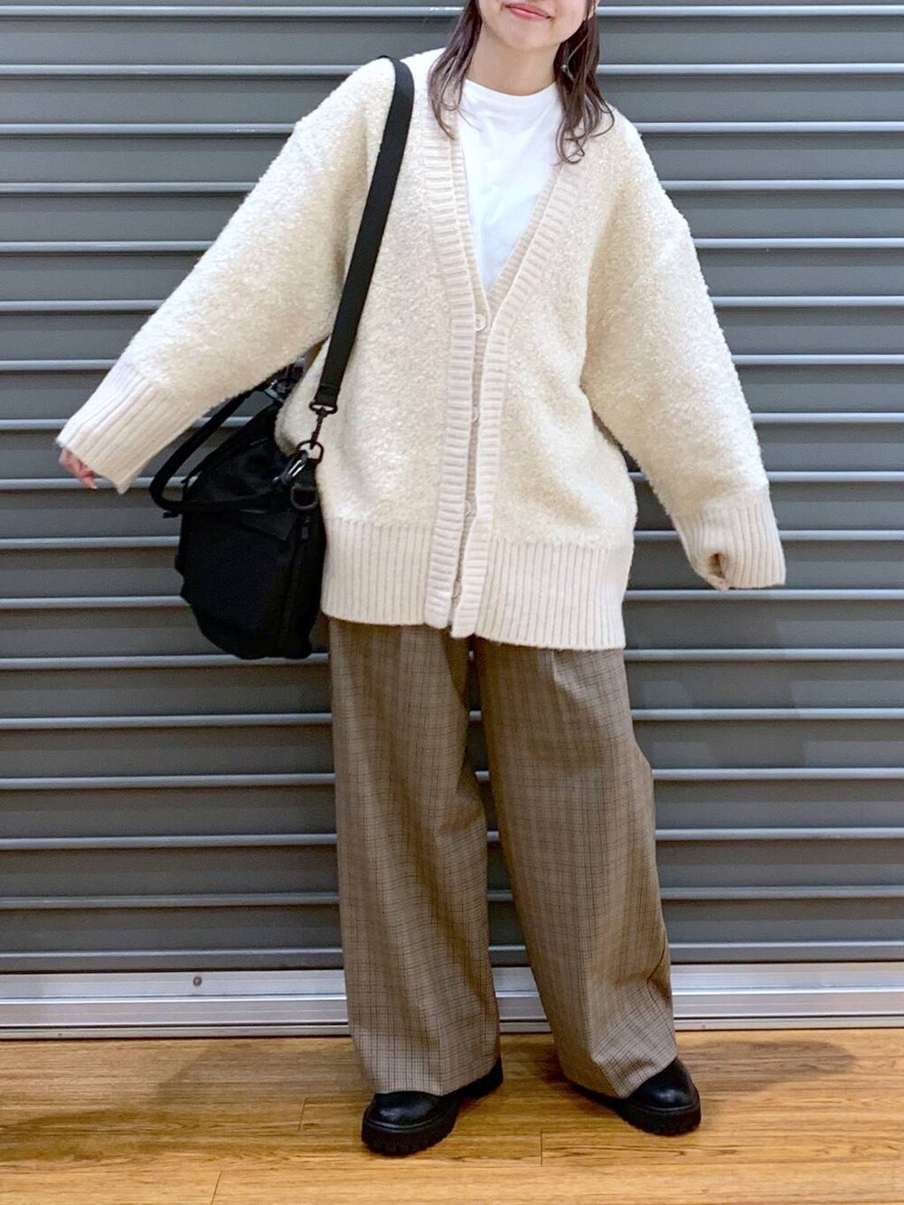 ブラック系のショルダーバッグ、ブラック系のブーツ、ホワイト系のカーディガン/ボレロを着用したレディースの秋コーディネートの3枚目の写真