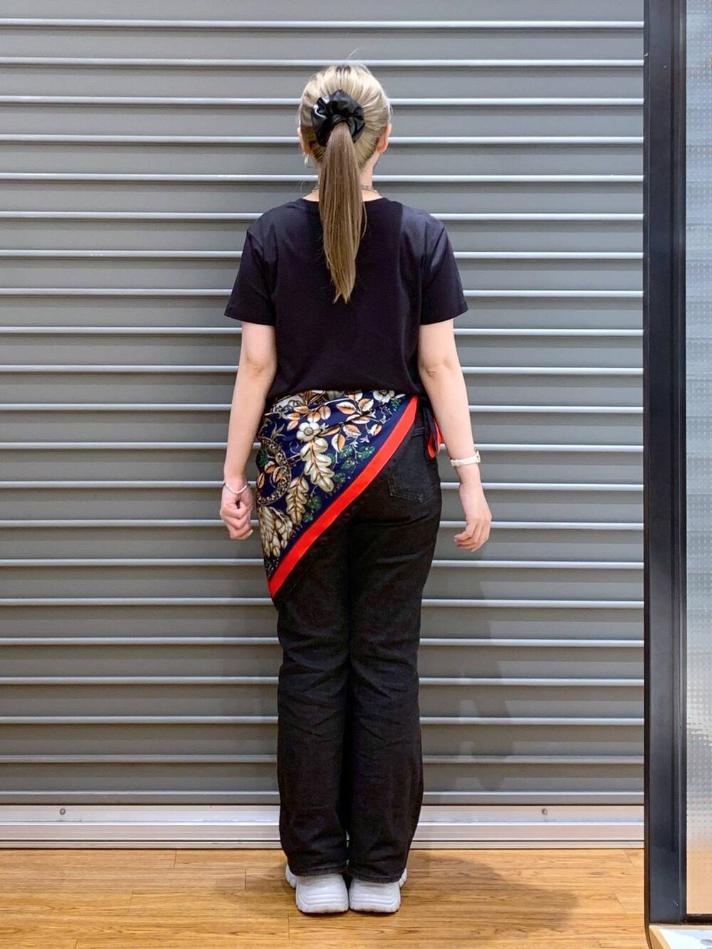 ブラック系のTシャツ/カットソー、ブラック系のデニムパンツ、シルバー系のスニーカーを着用したレディースの春コーディネートの2枚目の写真