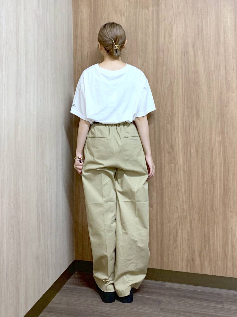 ベージュ系のチノパンツ、ブラック系のサンダル、ホワイト系のTシャツ/カットソーを着用したレディースの夏コーディネートの2枚目の写真