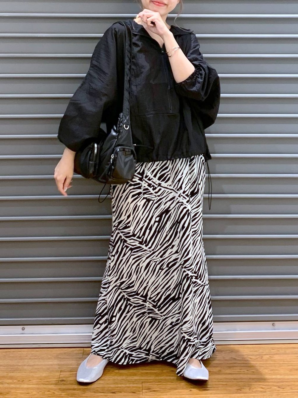 ブラック系のショルダーバッグ、シルバー系のパンプス、ブラック系のパーカーを着用したレディースの秋コーディネートの3枚目の写真