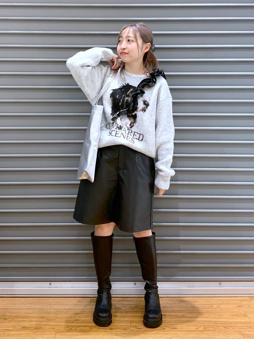 シルバー系のトートバッグ、ブラック系のブーツ、ブラック系のその他パンツを着用したレディースの冬コーディネートの6枚目の写真