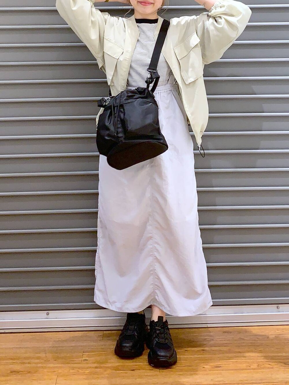 ブラック系のスニーカー、グレー系のTシャツ/カットソー、グレー系のスカートを着用したレディースの春コーディネートの6枚目の写真