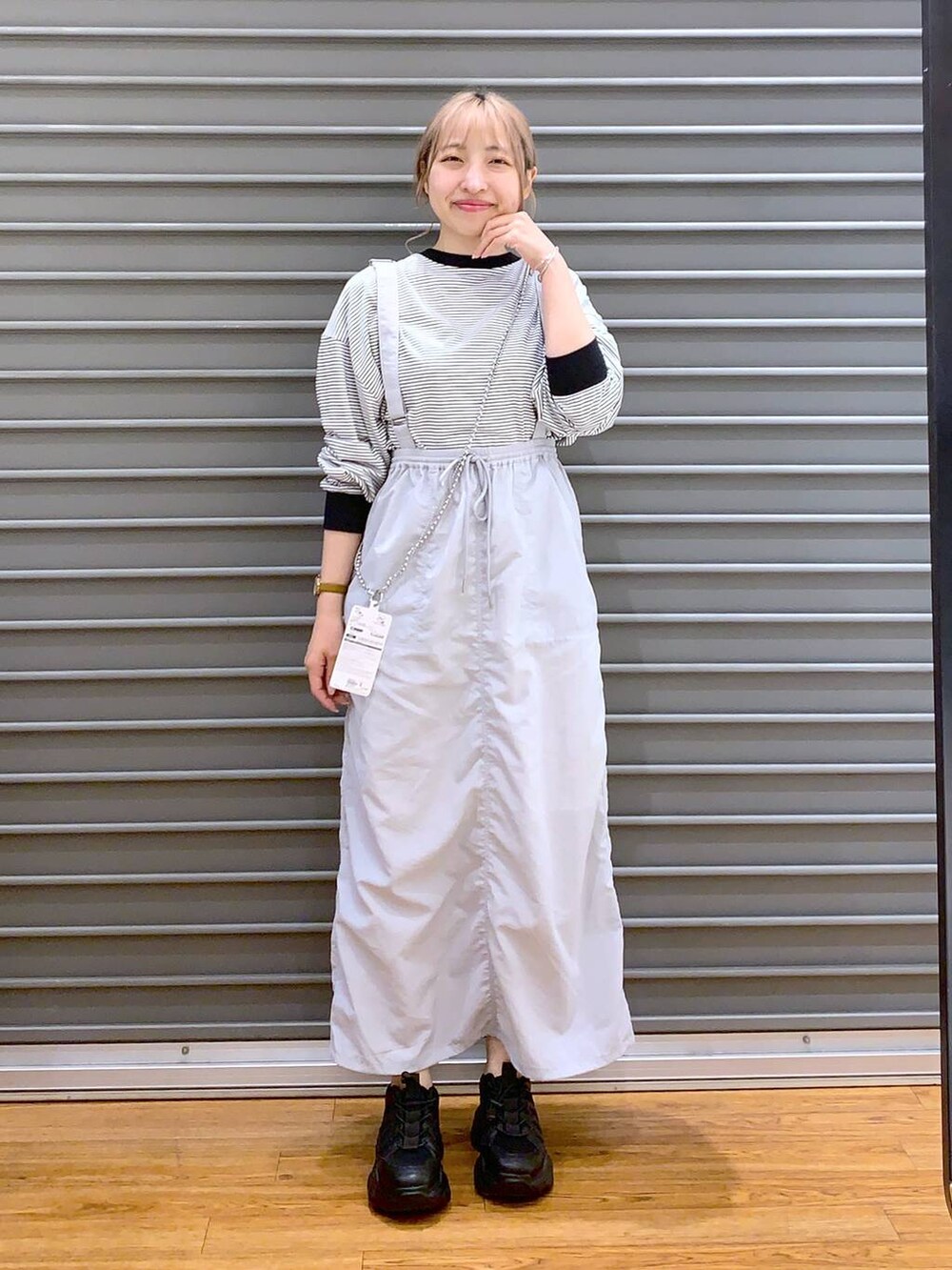 ブラック系のスニーカー、グレー系のTシャツ/カットソー、グレー系のスカートを着用したレディースの春コーディネートの3枚目の写真