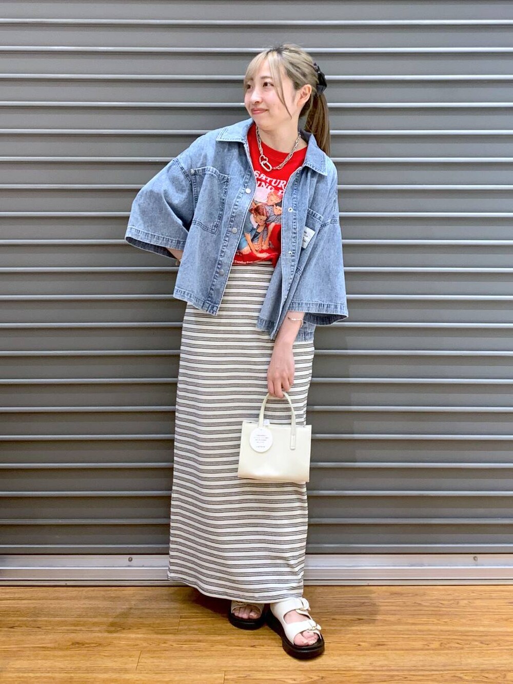 ブラック系のスカート、ホワイト系のサンダル、ホワイト系のショルダーバッグを着用したレディースの夏コーディネートの6枚目の写真