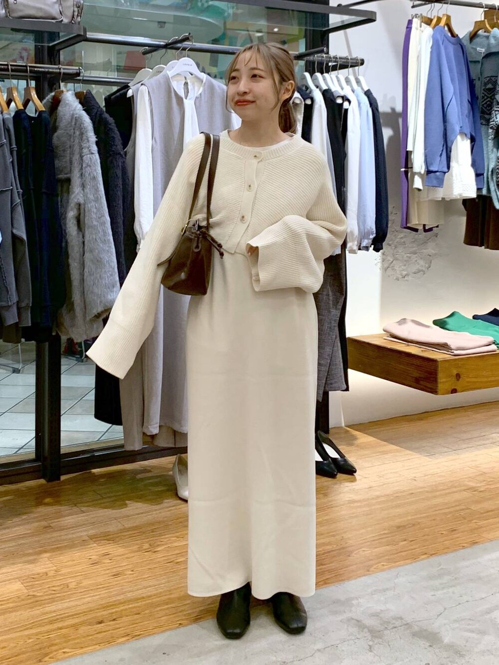 ブラック系のブーツ、ホワイト系のワンピース、ブラウン系のショルダーバッグを着用したレディースの冬コーディネートの4枚目の写真