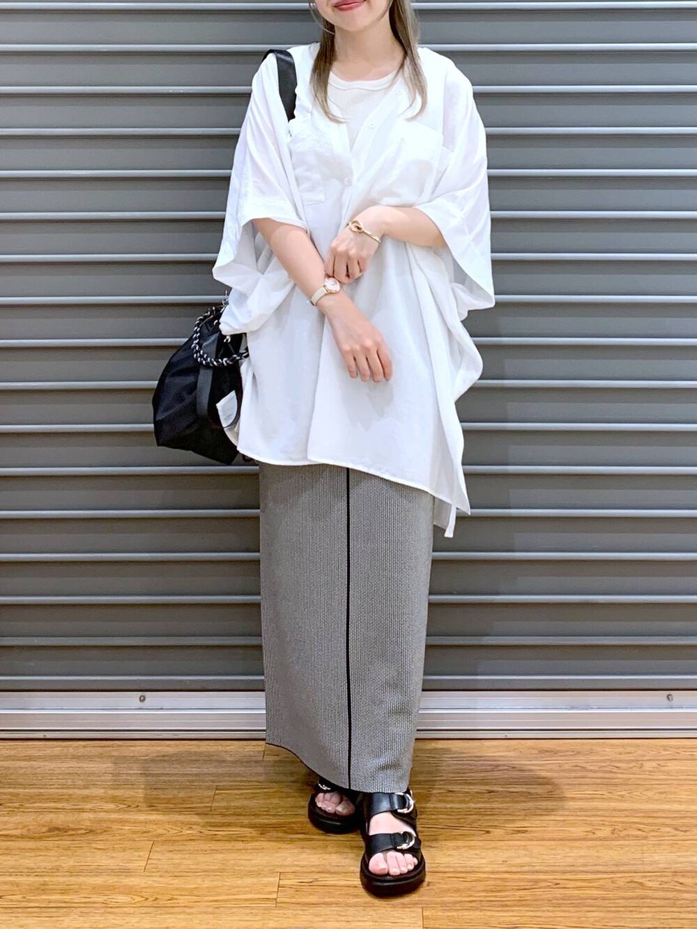 ホワイト系のTシャツ/カットソー、ブラック系のスカート、ブラック系のサンダルを着用したレディースの夏コーディネートの7枚目の写真