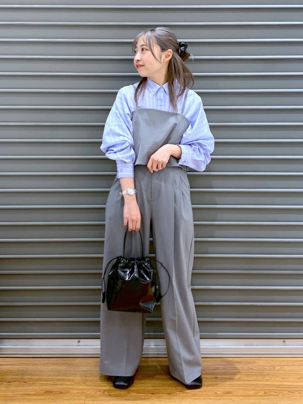 ブルー系のシャツ/ブラウス、グレー系のその他パンツ、ブラック系のパンプスを着用したレディースの春コーディネートの3枚目の写真