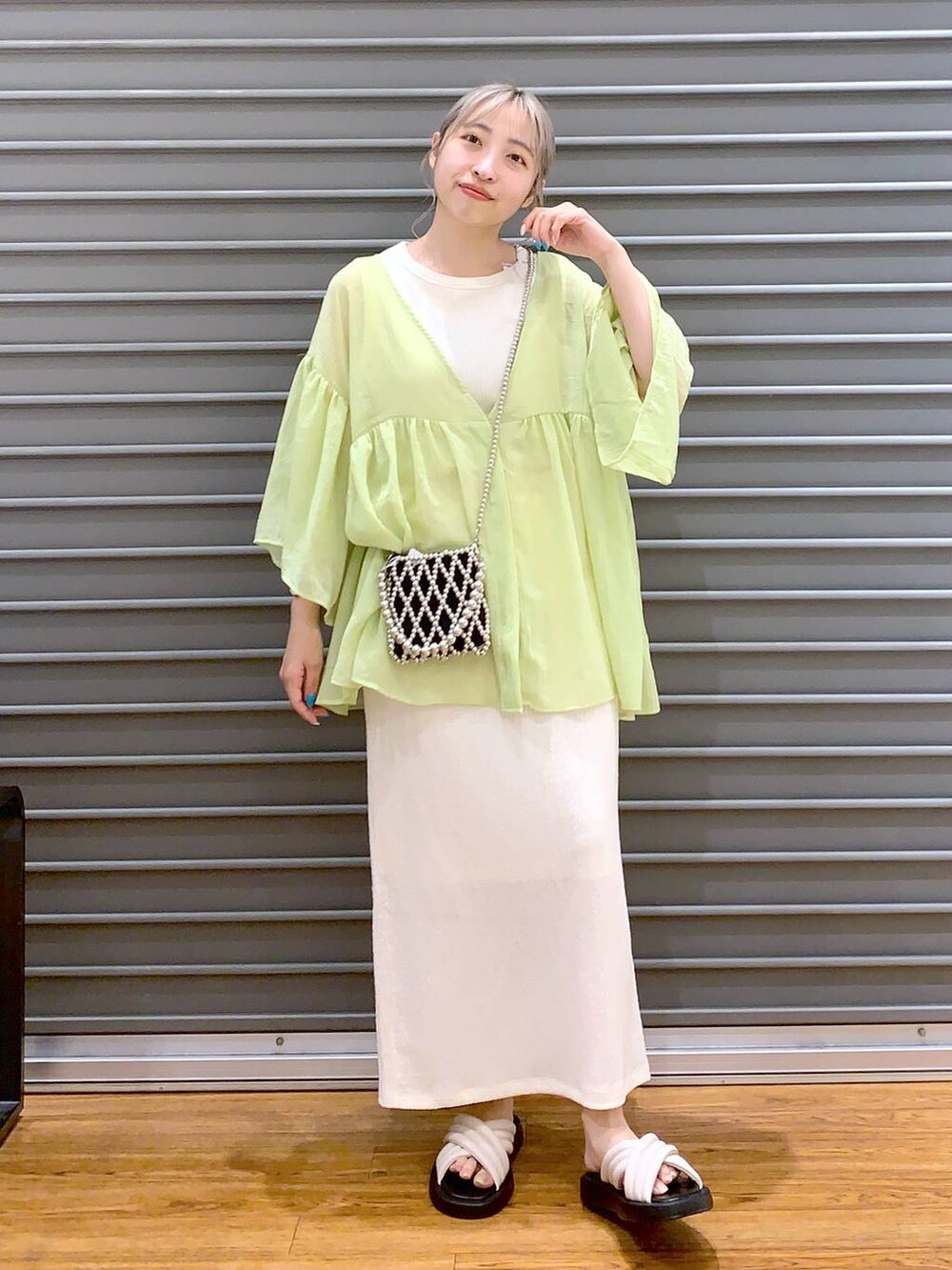 ホワイト系のタンクトップ、イエロー系のシャツ/ブラウス、ホワイト系のスカートを着用したレディースの夏コーディネートの5枚目の写真
