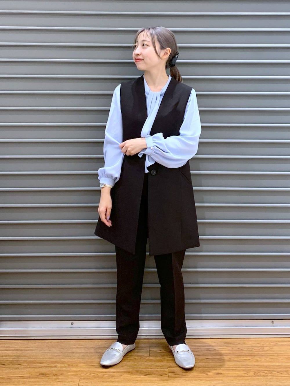 ブラック系のスーツパンツ、ブルー系のシャツ/ブラウス、ブラック系のスーツベストを着用したレディースの冬コーディネートの6枚目の写真