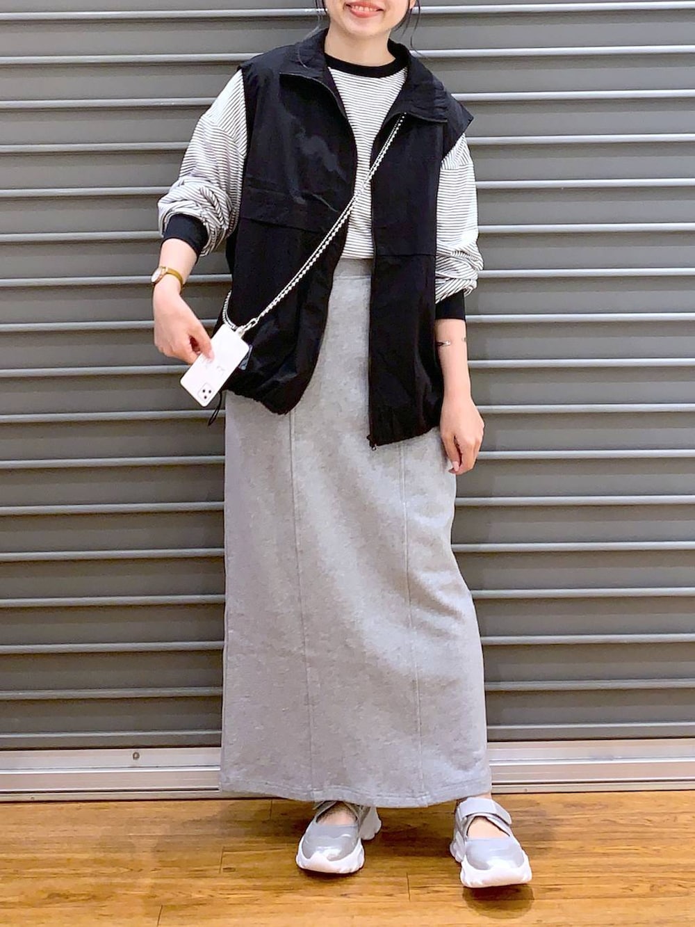 ブラック系のベスト、シルバー系のサンダル、グレー系のTシャツ/カットソーを着用したレディースの春コーディネートの3枚目の写真