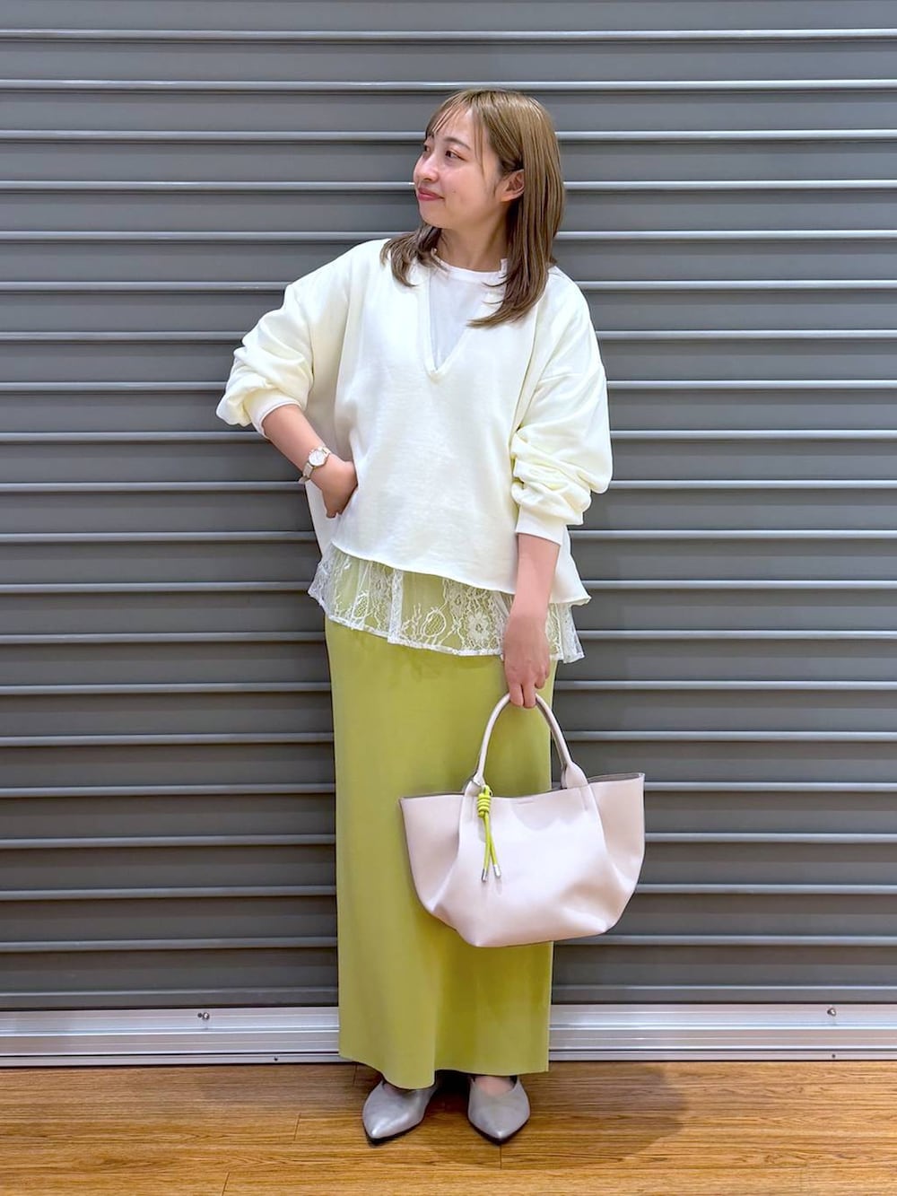 グリーン系のスカート、ホワイト系のTシャツ/カットソー、シルバー系のパンプスを着用したレディースの冬コーディネートの6枚目の写真