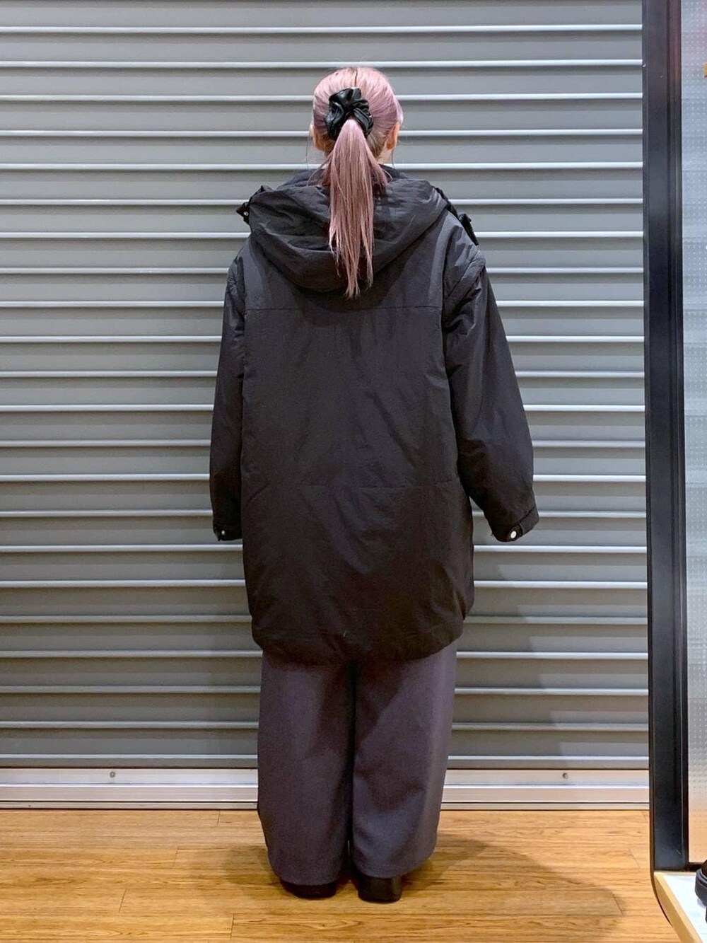 ブラック系のその他アウター、ブラック系のブーツ、ブラック系のショルダーバッグを着用したレディースの冬コーディネートの2枚目の写真