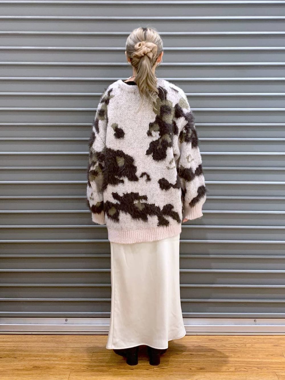 ホワイト系のスカート、ブラック系のショルダーバッグ、ブラック系のブーツを着用したレディースの冬コーディネートの2枚目の写真