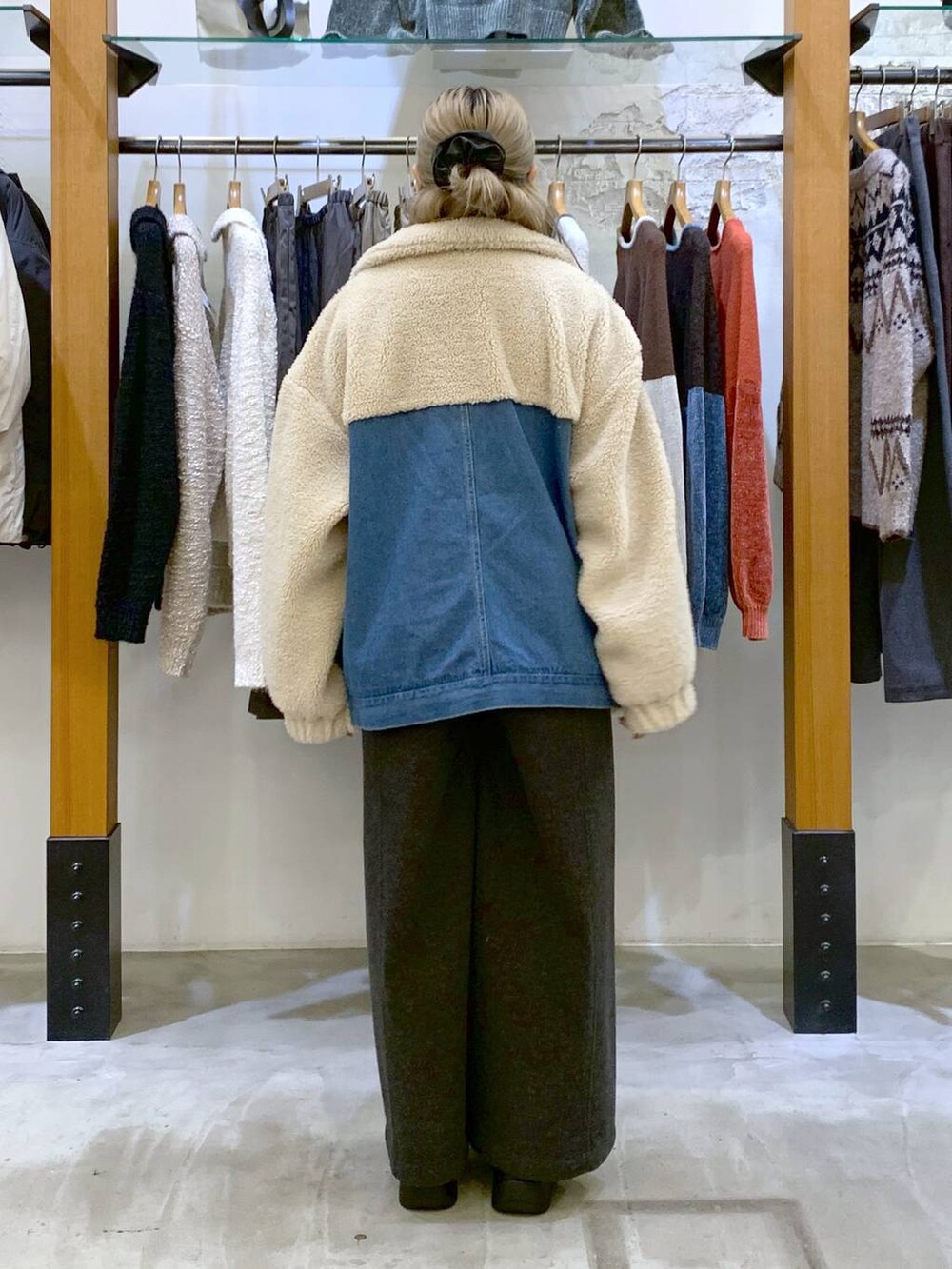 グレー系のその他パンツ、ホワイト系のニット/セーター、ブラック系のブーツを着用したレディースの秋コーディネートの2枚目の写真