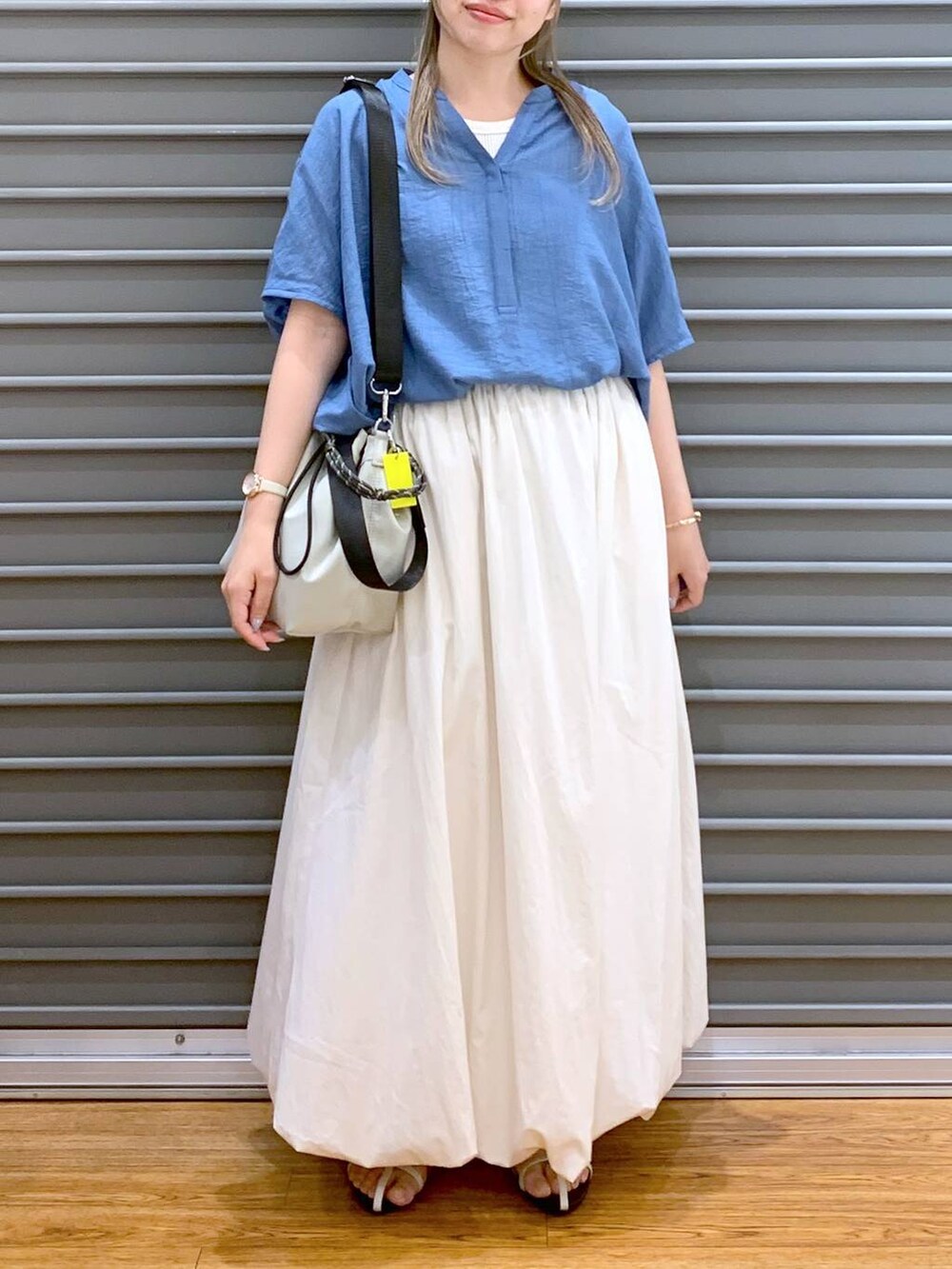 ホワイト系のサンダル、ホワイト系のスカート、グレー系のショルダーバッグを着用したレディースの夏コーディネートの5枚目の写真