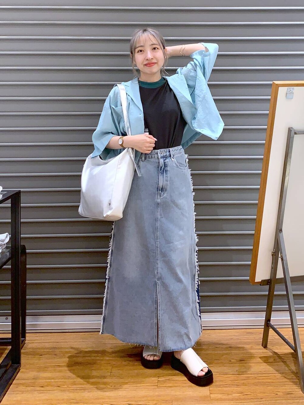 グレー系のタンクトップ、グレー系のショルダーバッグ、ホワイト系のサンダルを着用したレディースの夏コーディネートの3枚目の写真