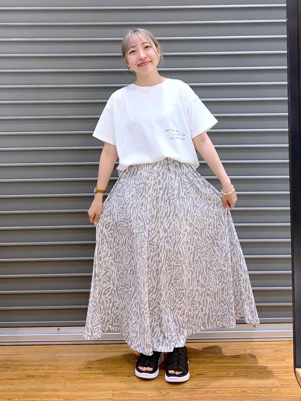 ブラック系のサンダル、ブラック系のショルダーバッグ、ホワイト系のスカートを着用したレディースの春コーディネートの6枚目の写真