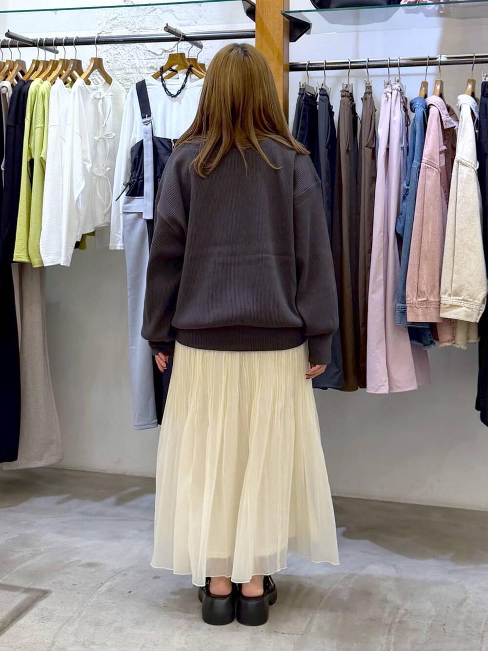 ブラック系のサンダル、ブラック系のボストンバッグ、ホワイト系のスカートを着用したレディースの春コーディネートの2枚目の写真