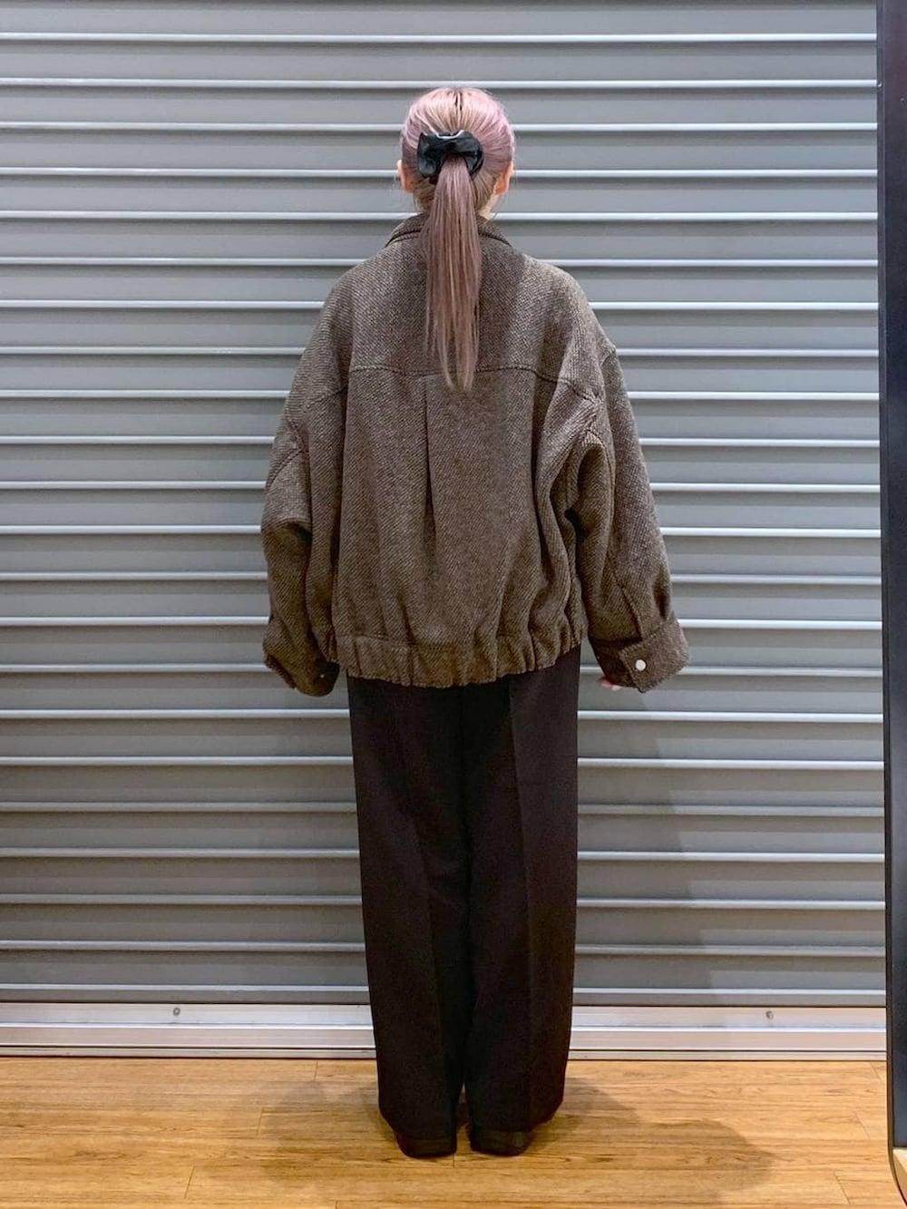 ブラウン系のブルゾン、ブラック系のブーツ、ブラック系のその他パンツを着用したレディースの冬コーディネートの2枚目の写真