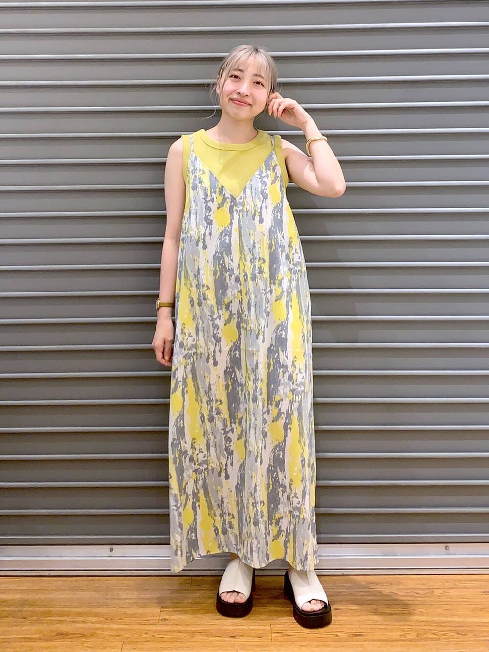 イエロー系のワンピース、イエロー系のタンクトップ、ホワイト系のショルダーバッグを着用したレディースの春コーディネートの3枚目の写真