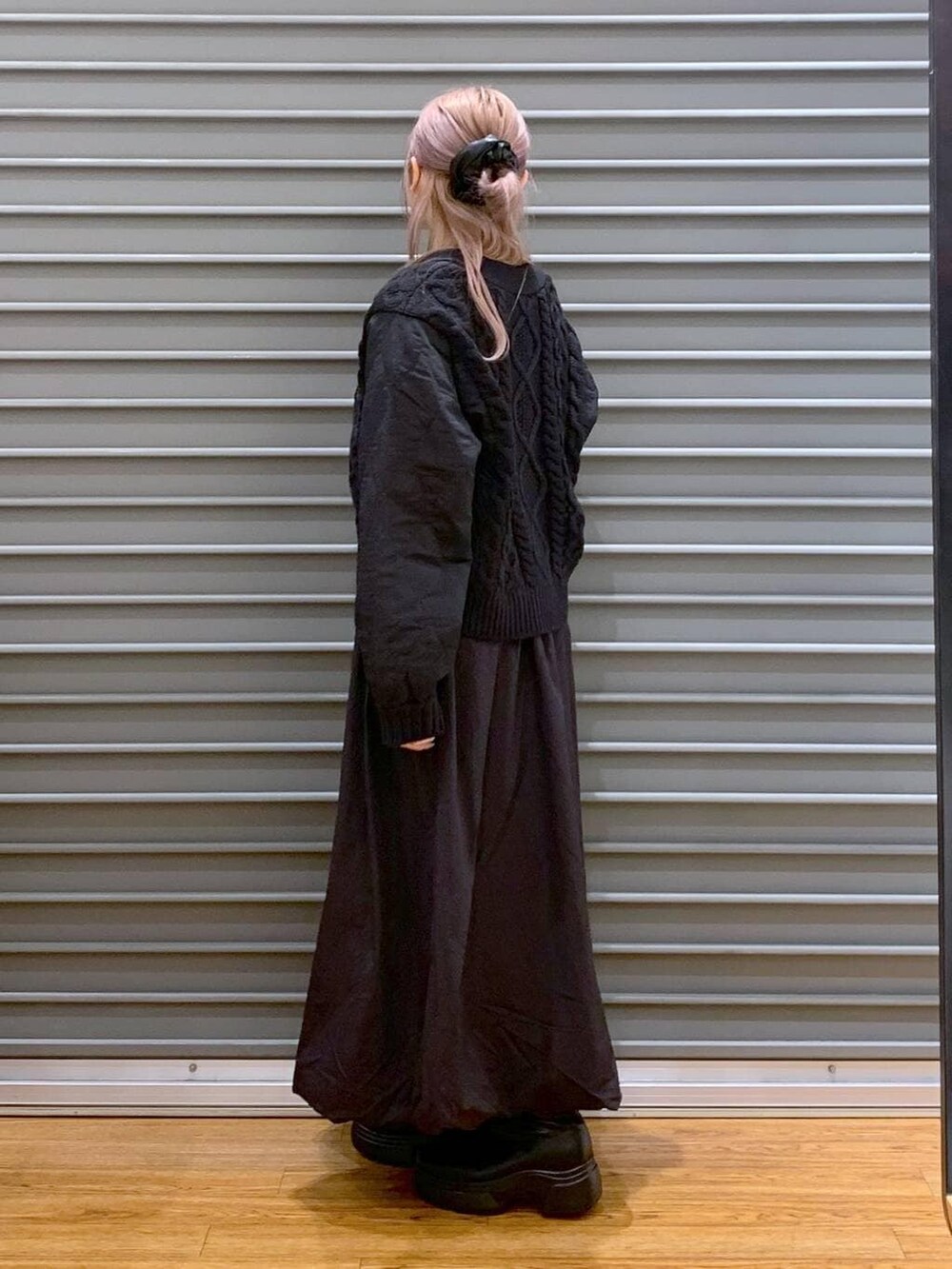 グレー系のショルダーバッグ、ブラック系のカーディガン/ボレロ、ブラック系のブーツを着用したレディースの冬コーディネートの3枚目の写真