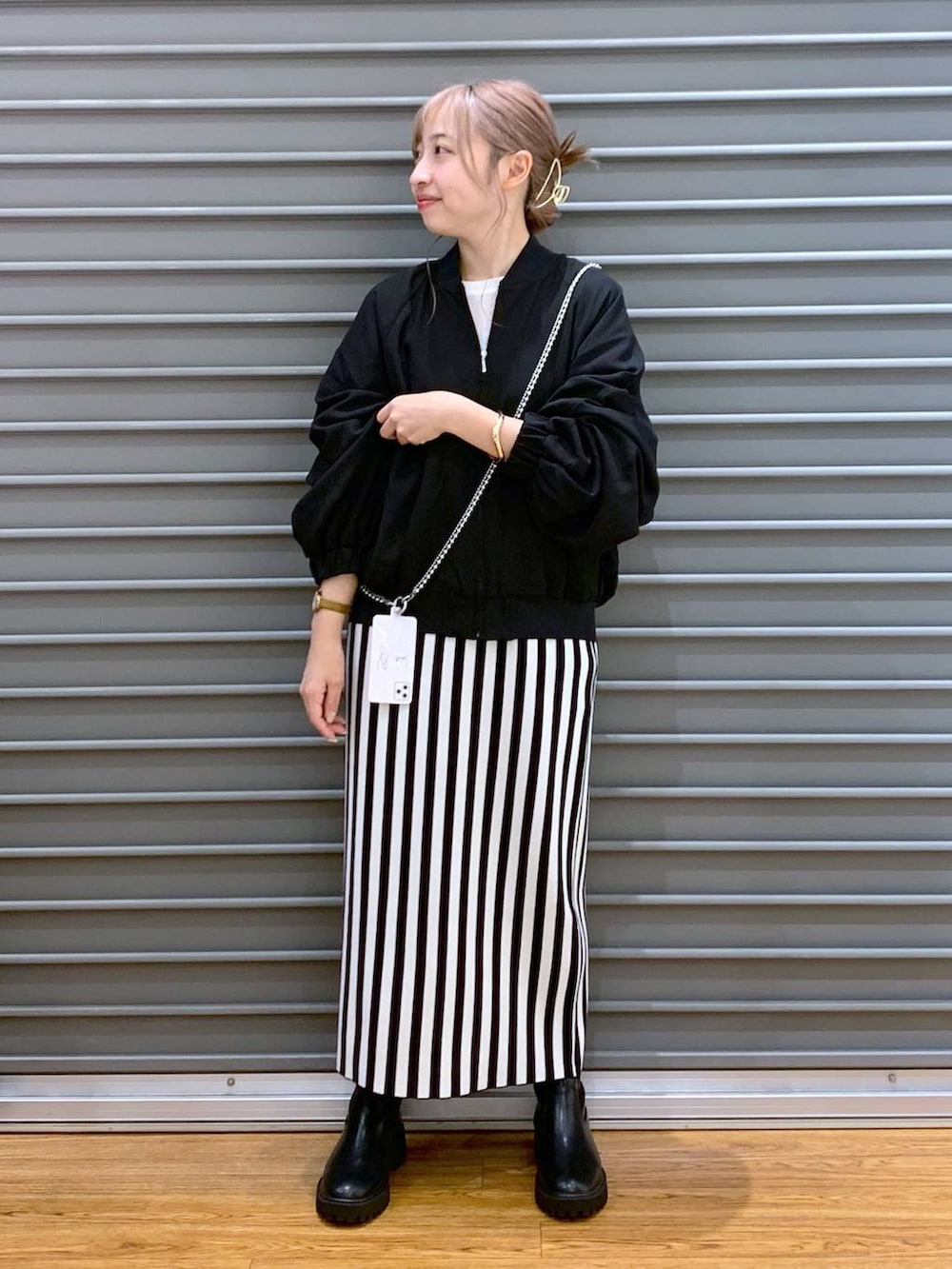 ブラック系のブルゾン、ブラック系のスカート、ブラック系のブーツを着用したレディースの秋コーディネートの3枚目の写真