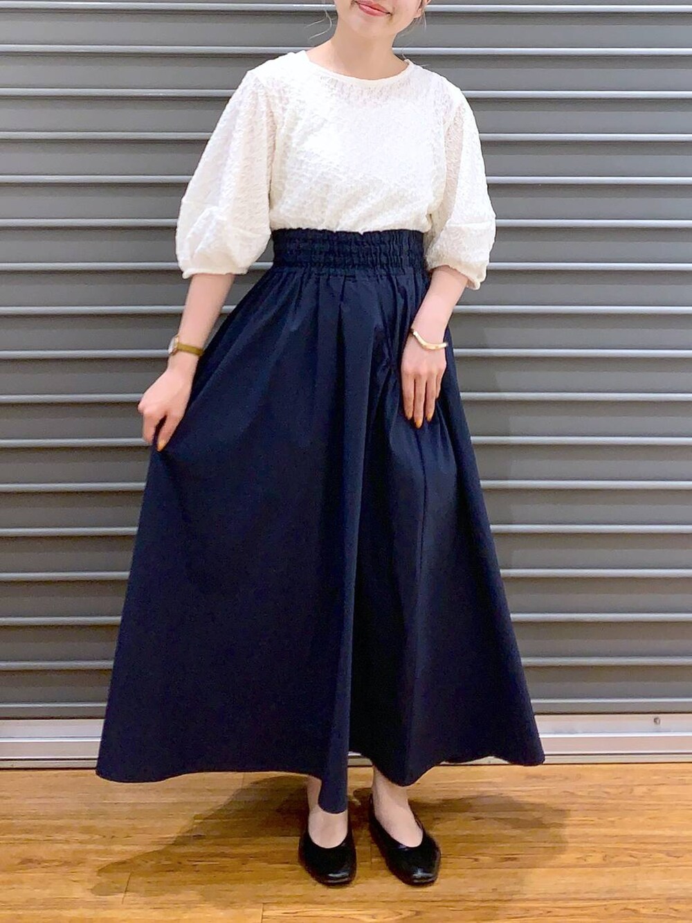 ホワイト系のショルダーバッグ、ブラック系のパンプス、ブルー系のスカートを着用したレディースの春コーディネートの5枚目の写真