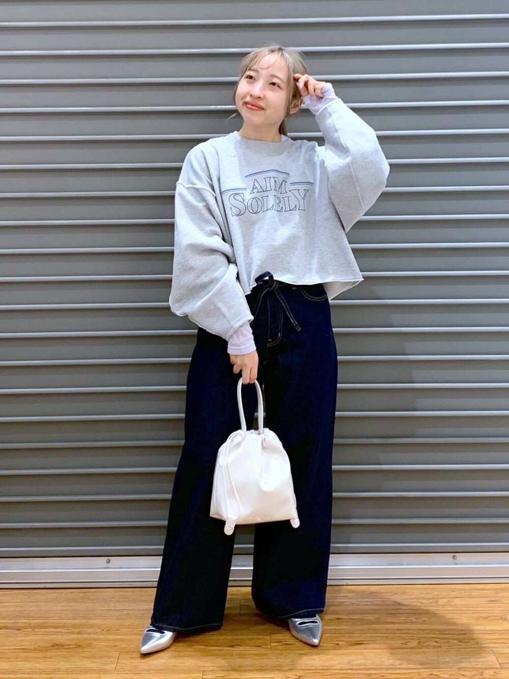 パープル系のTシャツ/カットソー、ブルー系のデニムパンツ、シルバー系のパンプスを着用したレディースの冬コーディネートの3枚目の写真