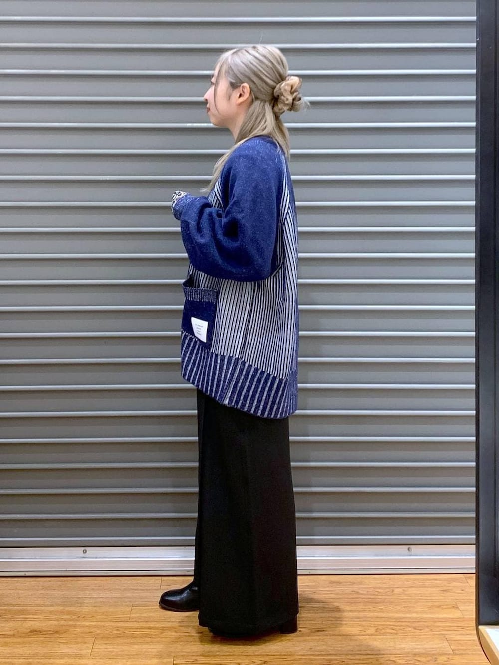 ブラック系のTシャツ/カットソー、ブルー系のカーディガン/ボレロ、ブラック系のボストンバッグを着用したレディースの冬コーディネートの3枚目の写真