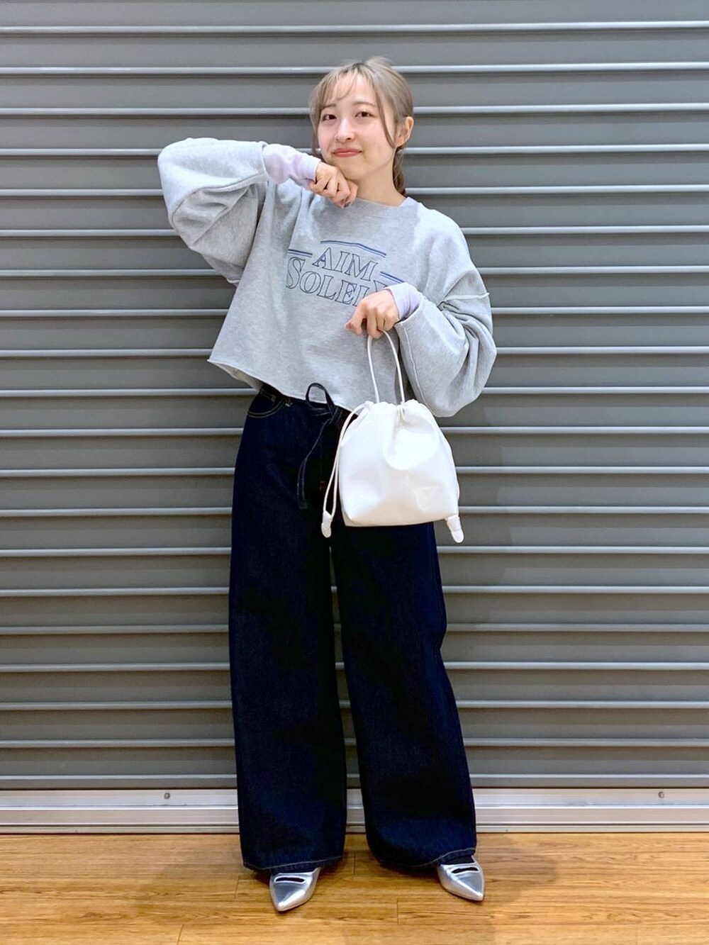 パープル系のTシャツ/カットソー、ブルー系のデニムパンツ、シルバー系のパンプスを着用したレディースの冬コーディネートの5枚目の写真