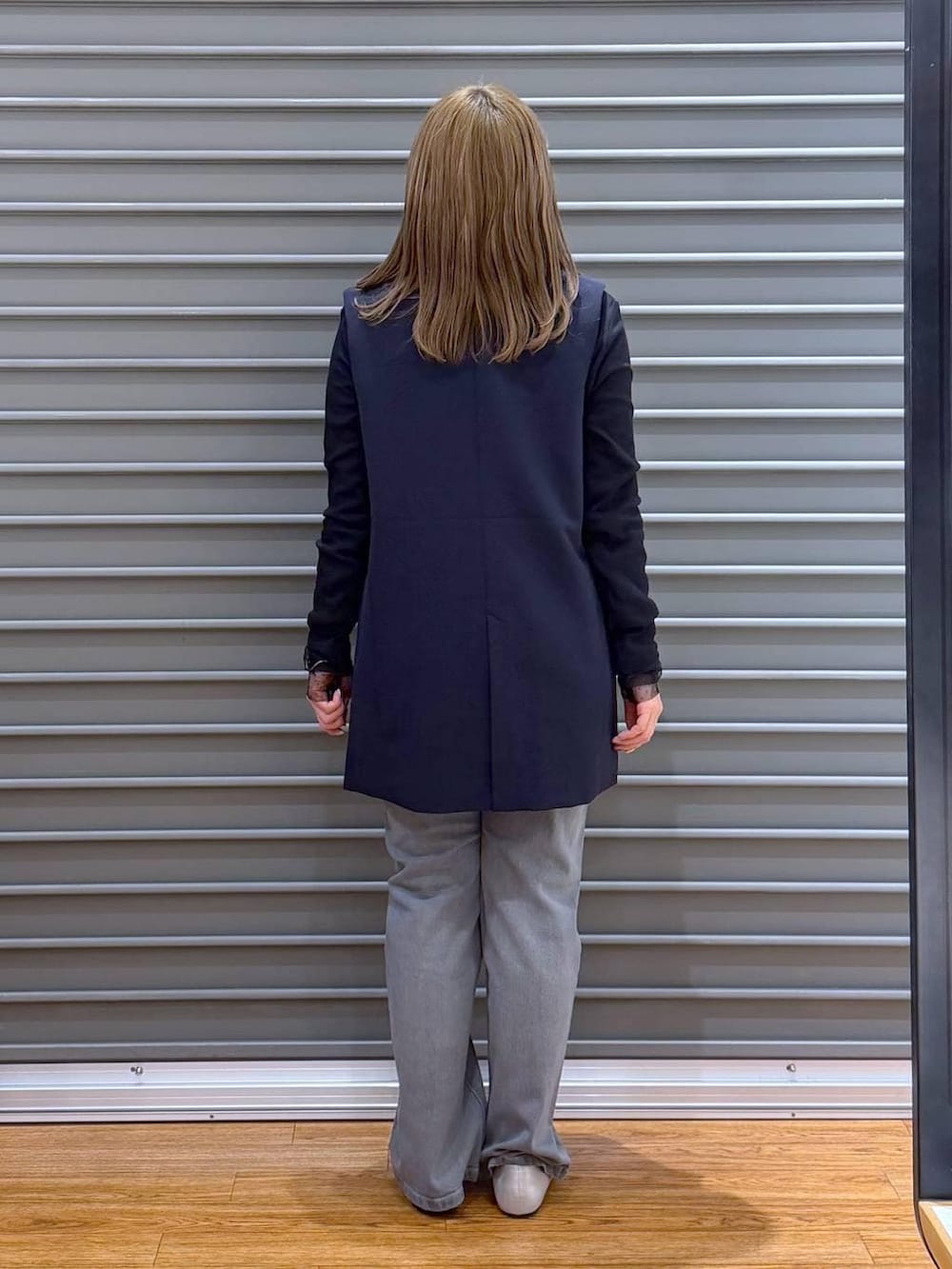 グレー系のショルダーバッグ、ブルー系のその他アウター、ブラック系のTシャツ/カットソーを着用したレディースの冬コーディネートの2枚目の写真