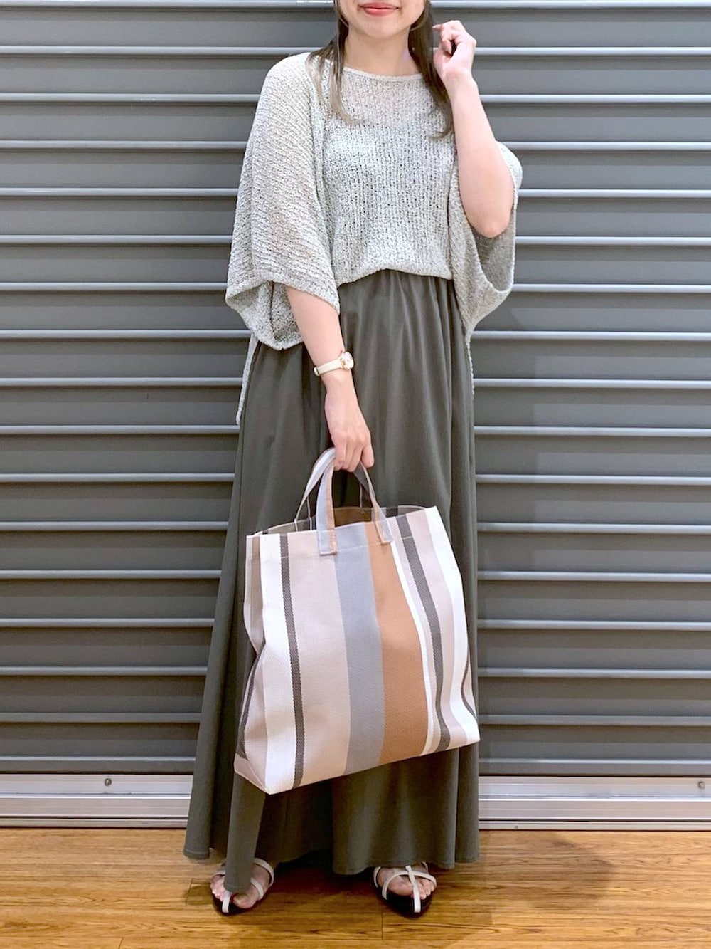 ベージュ系のニット/セーター、ホワイト系のサンダル、ベージュ系のトートバッグを着用したレディースの夏コーディネートの4枚目の写真