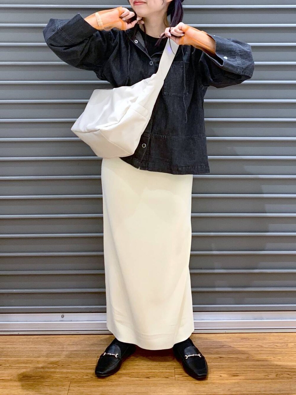 ブラック系のTシャツ/カットソー、ブラック系のローファー、ホワイト系のスカートを着用したレディースの春コーディネートの8枚目の写真