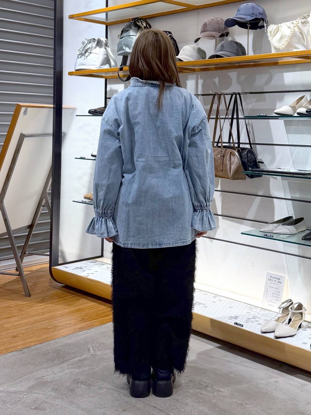 ブラック系のサンダル、グレー系のボストンバッグ、ブラック系のその他パンツを着用したレディースの冬コーディネートの2枚目の写真