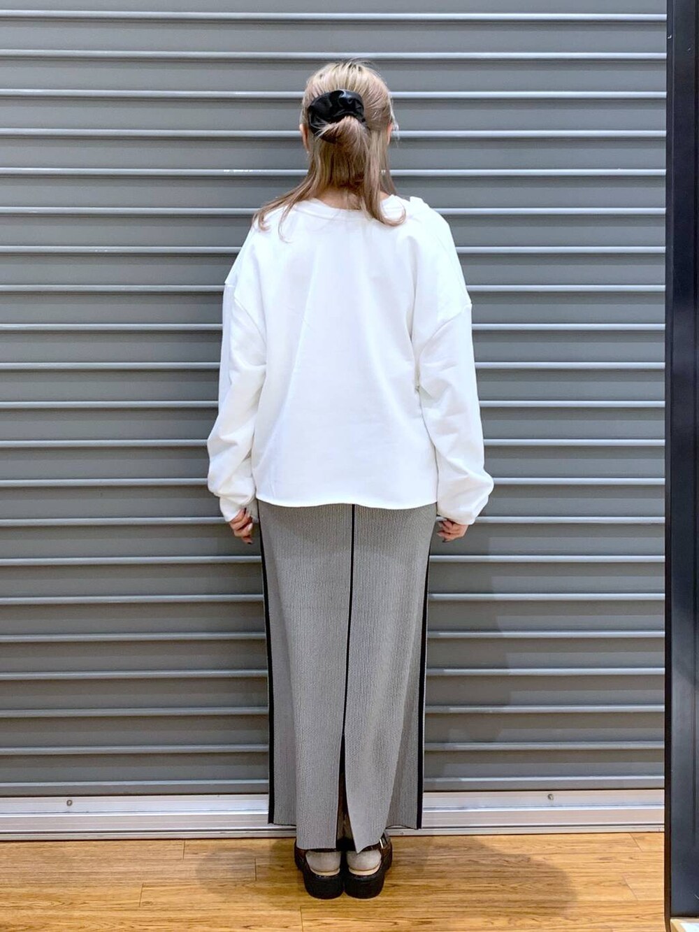 ピンク系のショルダーバッグ、ブラック系のローファー、ブラック系のスカートを着用したレディースの春コーディネートの2枚目の写真