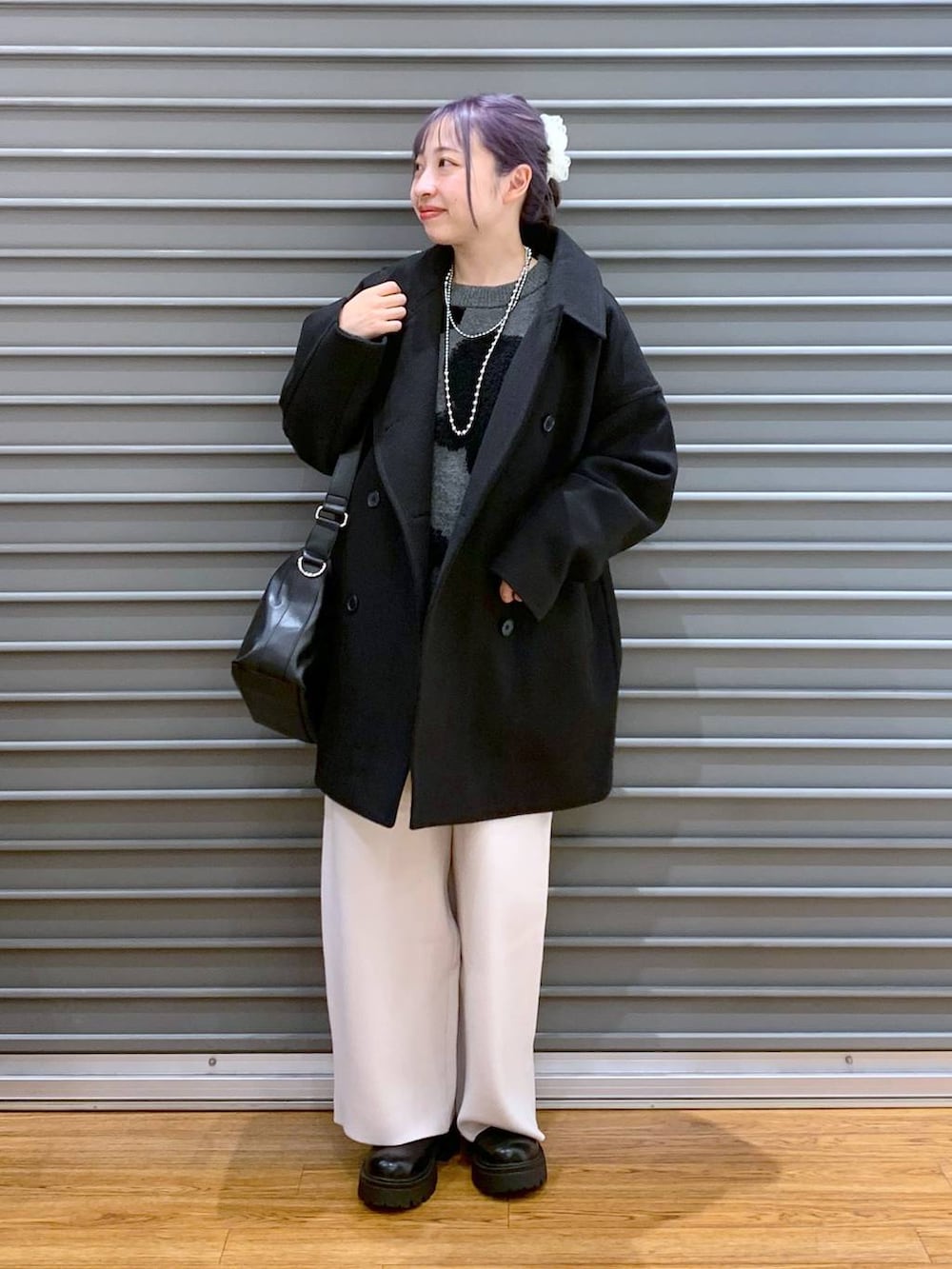 ブラック系のその他アウター、ベージュ系のその他パンツ、ブラック系のショルダーバッグを着用したレディースの冬コーディネートの6枚目の写真