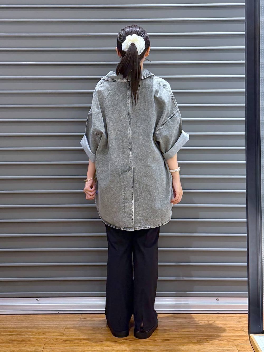 ブラック系のショルダーバッグ、グレー系のTシャツ/カットソー、ブラック系のサンダルを着用したレディースの夏コーディネートの2枚目の写真