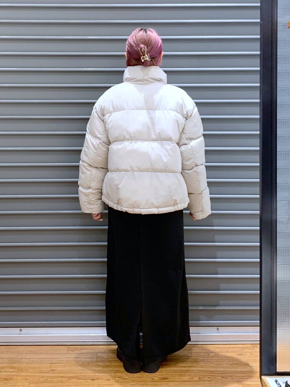 ベージュ系のダウンジャケット/コート、ブラック系のワンピース、ブラック系のブーツを着用したレディースの冬コーディネートの2枚目の写真