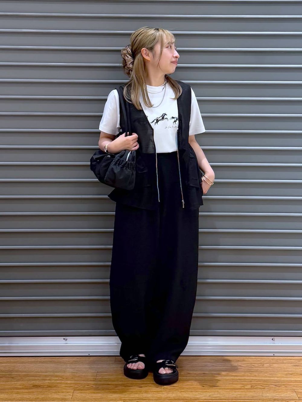 ブラック系のサンダル、ブラック系のその他パンツ、ブラック系のボストンバッグを着用したレディースの春コーディネートの6枚目の写真