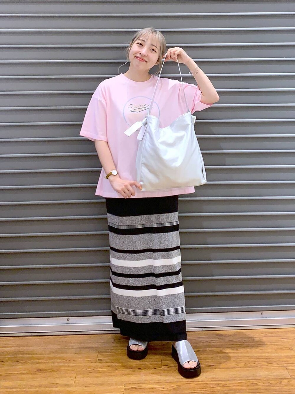 グレー系のショルダーバッグ、グレー系のサンダル、ブラック系のスカートを着用したレディースの春コーディネートの4枚目の写真