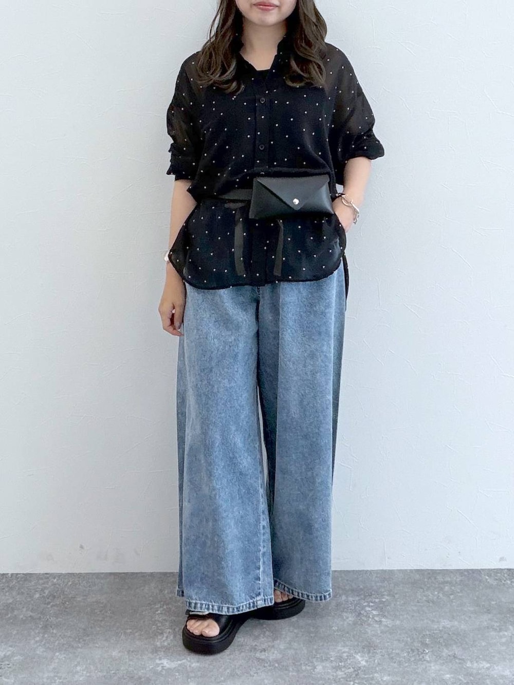 ブラック系のサンダル、ブルー系のデニムパンツ、ブラック系のベルトを着用したレディースの秋コーディネートの2枚目の写真