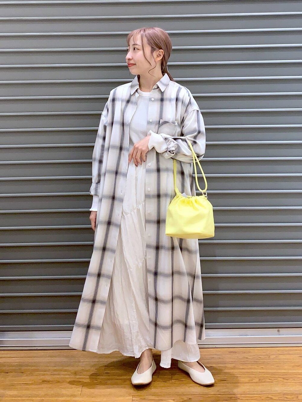 イエロー系のショルダーバッグ、ホワイト系のパンプス、ホワイト系のTシャツ/カットソーを着用したレディースの春コーディネートの4枚目の写真