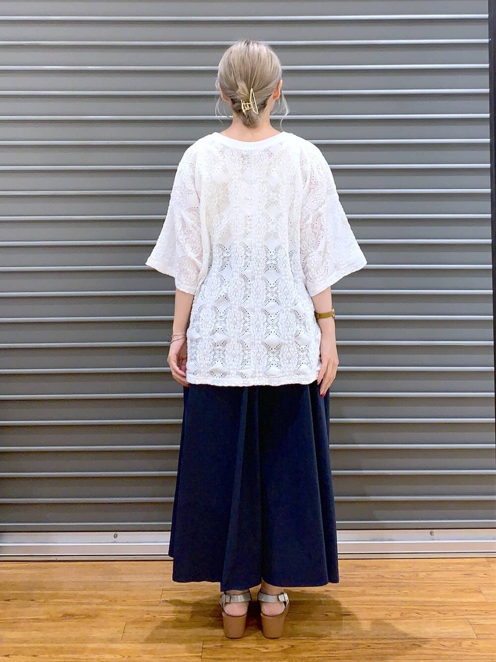 ブルー系のスカート、シルバー系のサンダル、ホワイト系のかごバッグを着用したレディースの夏コーディネートの2枚目の写真