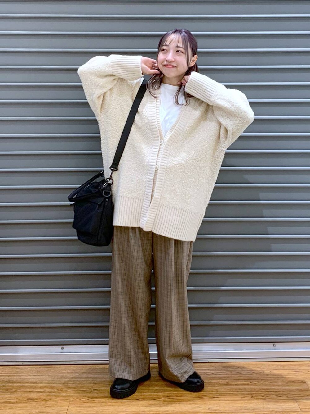 ブラック系のショルダーバッグ、ブラック系のブーツ、ホワイト系のカーディガン/ボレロを着用したレディースの秋コーディネートの5枚目の写真