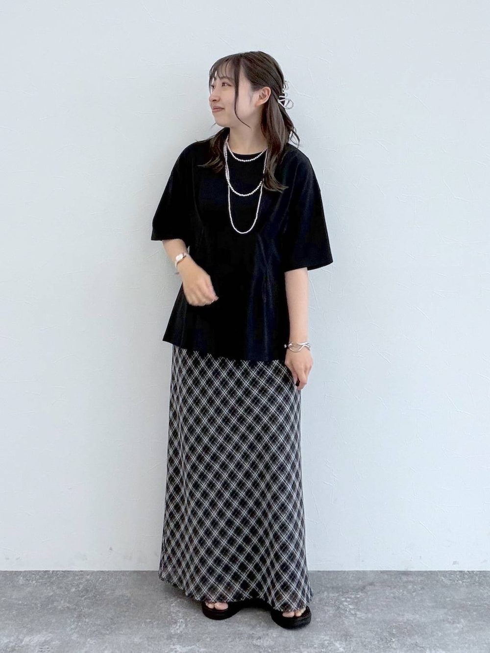 ブラック系のサンダル、ブラック系のスカート、ブラック系のTシャツ/カットソーを着用したレディースの夏コーディネートの5枚目の写真