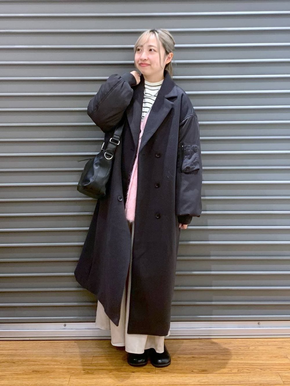 ブラック系のショルダーバッグ、ホワイト系のニット/セーター、ブラック系のブーツを着用したレディースの冬コーディネートの6枚目の写真