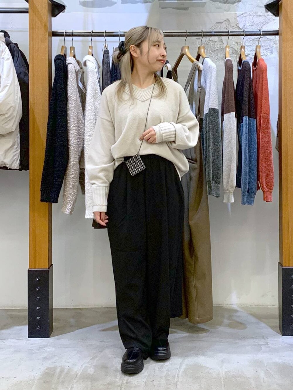 ブラック系のその他パンツ、ホワイト系のニット/セーター、ブラック系のブーツを着用したレディースの冬コーディネートの6枚目の写真