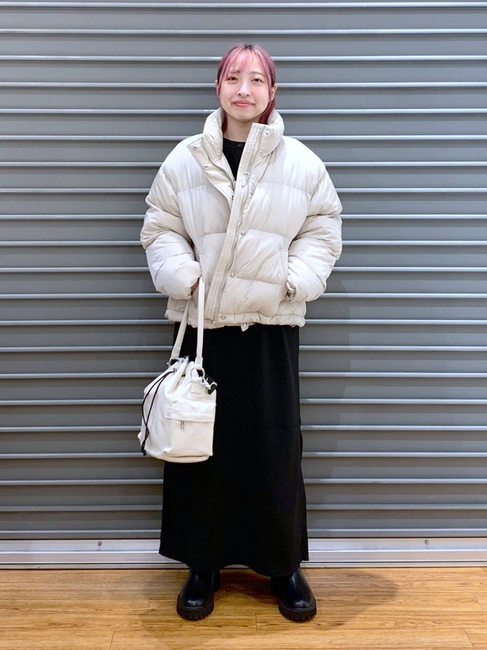 ベージュ系のダウンジャケット/コート、ブラック系のワンピース、ブラック系のブーツを着用したレディースの冬コーディネートの7枚目の写真