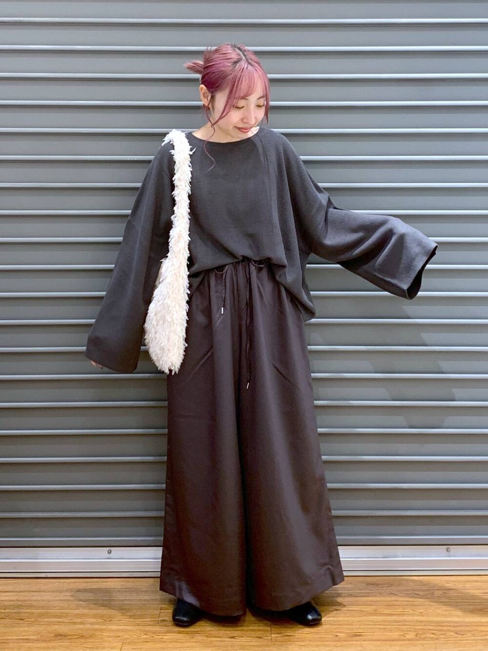 ホワイト系のショルダーバッグ、グレー系のニット/セーター、ブラック系のブーツを着用したレディースの秋コーディネートの4枚目の写真