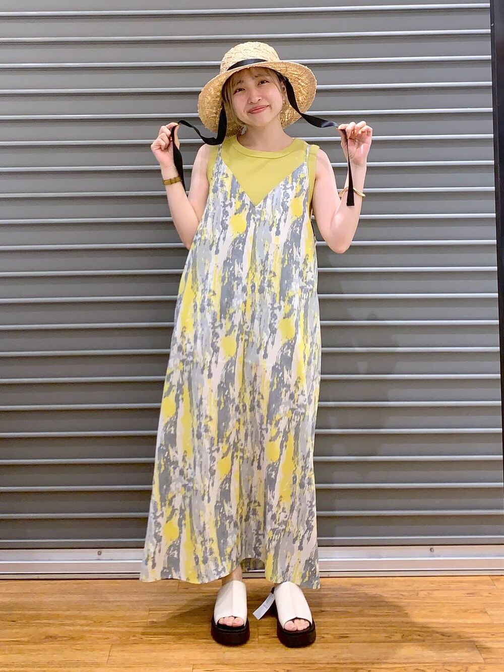 イエロー系のワンピース、イエロー系のタンクトップ、ホワイト系のショルダーバッグを着用したレディースの春コーディネートの4枚目の写真